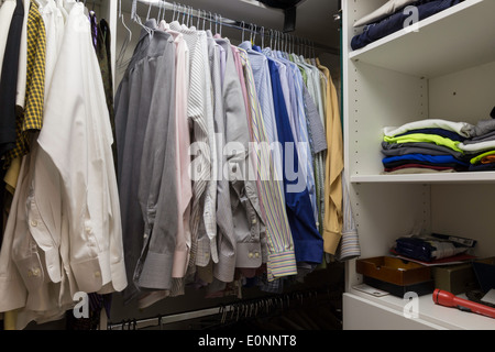 Home closet organized walk-in bedroom wardrobe of women fashion clothes  hanging on racks. Summer style, dresses and t-shirts Stock Photo