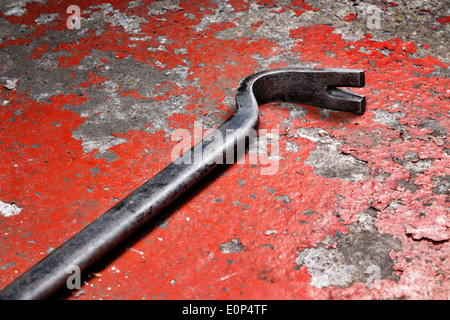 An old crowbar on a red background Stock Photo