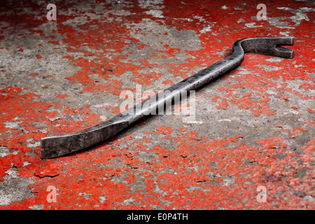 An old crowbar on a red background Stock Photo