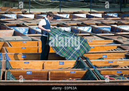 Cambridge UK , 18th May 2014. Staff at Scudamore's Boatyard prepare the punts for a busy Sunday punting on the River Cam, Cambridge UK as another warm sunny day is forecast.  The temperature is expected to reach 24 degrees centigrade.  Many tourists will take chauffeured punt trips along the river enjoying the sights of the historic University buildings.  Credit Julian Eales/Alamy Live News Stock Photo