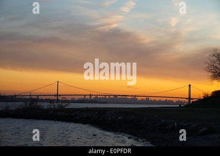 Sunset from the Throggs Neck of the Bronx at the East River looking toward the Whitestone Bridge and the New York City skyline. Stock Photo