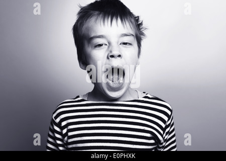 Black-and-white portrait of boy in striped vest singing. Original name: 'Solo part' Stock Photo