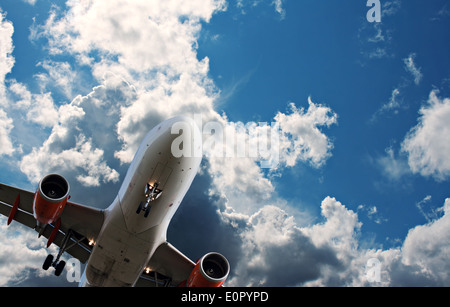 Passenger jet against a blue sky with white fluffy clouds Stock Photo