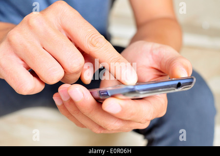 closeup of a young man using a smartphone Stock Photo