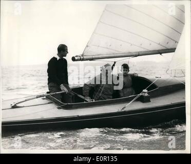 Aug. 08, 1957 - Prince Charles goes Yacht racing - with his father.. seen aboard the ''Bluebottle''.: Prince Charles accompanied his father the Duke of Edinburgh in the ''Bluebottle'' when competing in a Dragon class race a during the Cowes Regatta today. Photo shows Wearing a waterproof overalls Prince Charles seated between MFFA Fox and Lieut. Commander A.T. Easton - in the ''Bluebottle'' - at Cowes today. Stock Photo