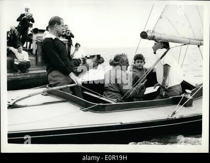Aug. 08, 1957 - Prince Charles goes yacht racing with his father. Duke at the Tiller Aboard:Prince Charles accompanied by his father the Duke of Edinburgh in the ''Bluebottle'' - when competing in a Dragon class race - during the   today. Photo shows the Duke at the  with Prince Charles and  fox seated - and on right Lieut. Commander A.T. Easton - in the ''Bluebottle'' at Cowes today. Stock Photo