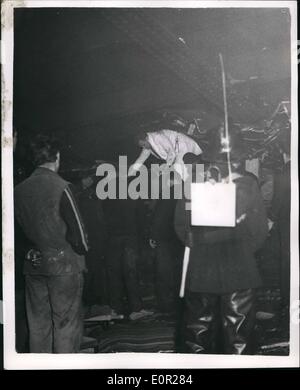 Dec. 12, 1957 - 4 killed and 200 injured in last night's lewisham rail disaster. Hope given up for many entombed. photo shows A doctor (in white coat) works to free victims from the coach of the steam train on which the fly-over bridge crashed at lawisbam last night. picture taken this afternoon. fireman and other rescue workers look on. Stock Photo