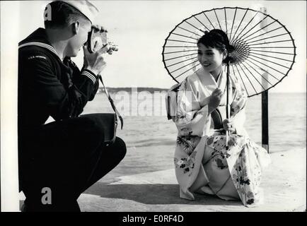May 05, 1959 - Cannes Film Festival: Madame Butterfly has found her sailor: Japanese Actress Hitmi Nozoe being photographed by an American Sailor while taking a walk on the beach yesterday. Stock Photo
