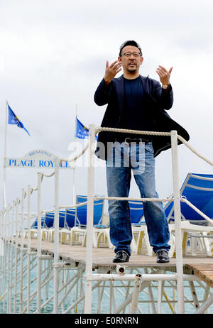 Cannes, France. 19th May, 2014. Chinese director and actor Jiang Wen stands on the beach of Cannes, France, on May 19, 2014. Jiang brought his new movie 'Gone with the bullets' for promotion during the 67th Cannes Film Festival. Credit:  Ye Pingfan/Xinhua/Alamy Live News Stock Photo