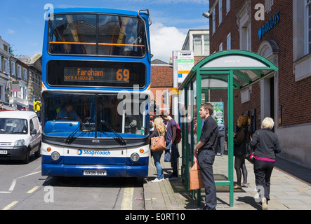 People boarding a bus at a bus stop, UK Stock Photo