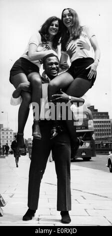 Boxer Smokin' Joe Frazier holding two women on his shoulders Stock Photo