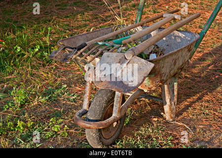 Gardening tools in old rusty wheelbarrow