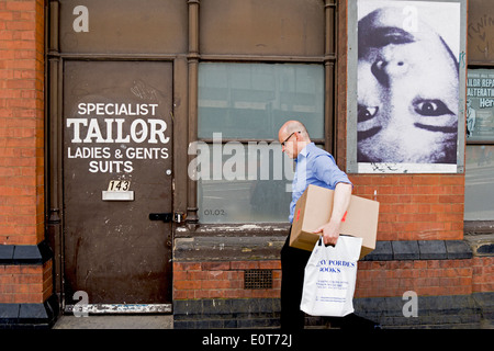 A man walks past a tailor's shop in London. Stock Photo