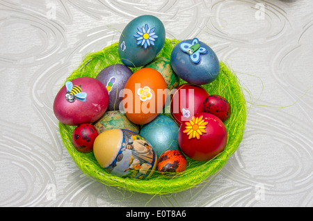 Easter eggs in a green pannier on the table Stock Photo