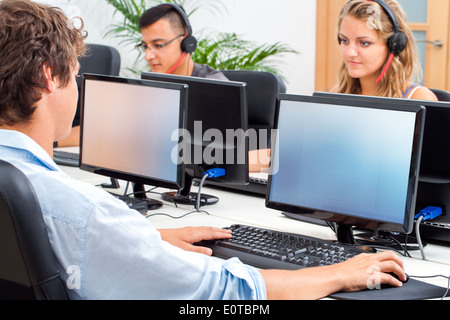 Group of students working on computers in classroom. Stock Photo