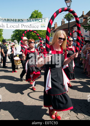 Female morris dancers dancing as part of the parade along Broad Street during the Alresford Watercress Festival 2014. Stock Photo