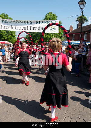 Female morris dancers dancing as part of the parade along Broad Street during the Alresford Watercress Festival 2014. Stock Photo