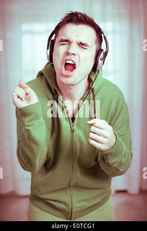 Crazy casual young man with headphones singing. Stock Photo