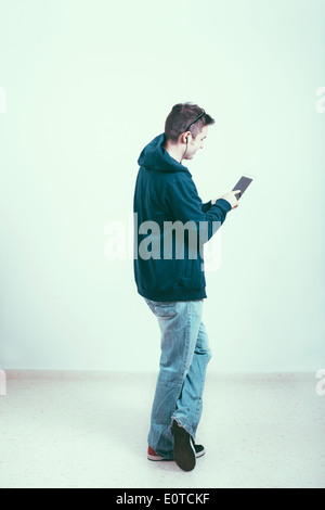 Young man in hoodie using digital tablet. Stock Photo