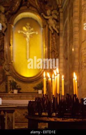 Candles in front of Jesus Christ on the Cross, religious symbols of christianity, Church of St. Mary Magdalene, Rome, Italy Stock Photo