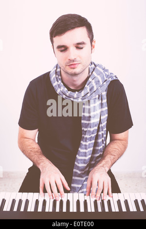 Portrait of young man playing piano. Stock Photo