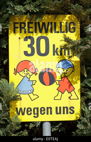 German traffic sign saying ´30 km voluntarily because of us´ Stock Photo