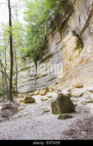 large sandstone cliffs with rocks that have fallen in the past turning into powder on the ground, St Louis State Park Illinois Stock Photo