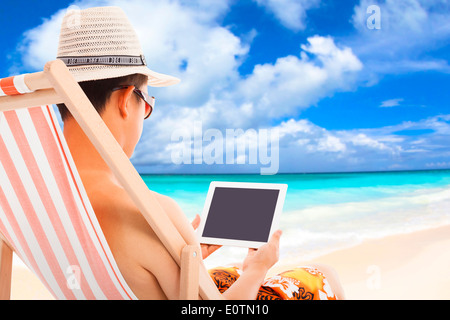 relaxed man sitting on beach chairs and touching tablet Stock Photo