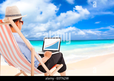 businessman sitting on beach chairs and look stock financial Stock Photo