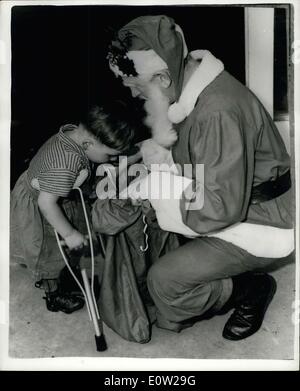 Dec. 19, 1960 - The Wonder of Christmas - at Australian Orthpaedic Hospital. Donald gets a present from ''Santa''.: Three year old cripple - Donald - using tiny crutches leans eagerly forward to peep into the sack - as SANTA CLAUS invites him to help-himself - when, complete with hundreds of toys - Santa made a very welcome visit to the Margaret Reid Orthopaedic Hospital, St. Ives, Sydney, Australia. Stock Photo