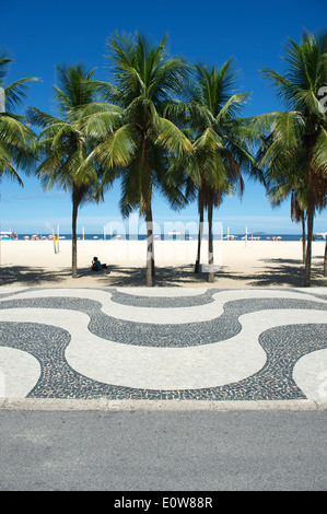 Iconic curving sidewalk tile pattern with palm trees at Copacabana Beach Rio de Janeiro Brazil Stock Photo