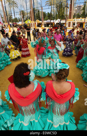 Women wearing gypsy dresses perform traditional Andalusian dances at the Feria del Caballo, Jerez de la Frontera Stock Photo