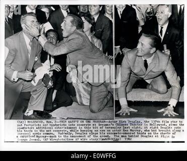 Nov. 02, 1962 - This wasn't on the program; Actor Kirk Douglas, the 137the film star to put footprints and handprints into conrete at Grauman's Chinese theater in Holly wood, gives the spectators additional entertainment in this bit of horseplay last night. At right Douglas puts his hands in the wet concrete, while keeping an eye on actor Ken Murray, who had brought along a personal movie camera. Suddenly, Douglas claps his concrete smeared hands on the checks of a surprised Murray much to the amusement of the crowd. The man behind Douglas at right is George Jessel. Stock Photo