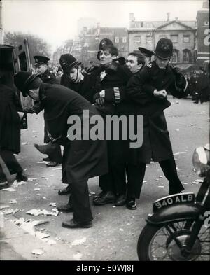 Mar. 03, 1963 - The Jobless Protest Outside House of commons. Five Policemen and one Demonstrator.: Several thousand Trade Unionist arrived in London this morning. and this afternoon marched to the house of communist with the intention of lobbying their M.P's.. On the unemployment situation.. There were a number of Skirmishes between the unemployed and the police. outside the house. Photo Shows Five Policemen struggle with one of the demonstrators- to cart to a police van. outside the house of Commons this afternoon. Stock Photo