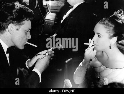 Elizabeth Taylor and Richard Burton having a cigarette at the premiere of 'Lawrence of Arabia' Stock Photo