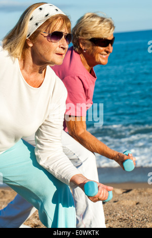 Elderly ladies doing workout on beach. Stock Photo