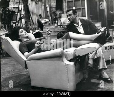 Aug. 08, 1963 - La Lollo - Takes It Easy... Super-Duper Chair - For The Star.. Screen star Gina (La Lollo'') Lollobrigida believes in taking it easy . She is pictured here chatting to co star Sean Connery while reclining on her oh-so-special Status symbol Chair.. And what chair it is specially made in sofa leather with movable back and leg rests on wheels.. And the purpose of it all is so that Gina can sit in comfort while waiting call during the shooting of ''Women of Straw'' - at Pinewood... No for her - the straight backed canvas studio chair - for after all - she is La Lollo! Stock Photo