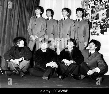 The Beatles sitting in front of the wax figures of themselves Stock Photo