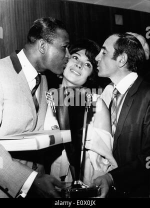 Sugar Ray Robinson and Charles Aznavour giving Dany Carrel a kiss Stock Photo