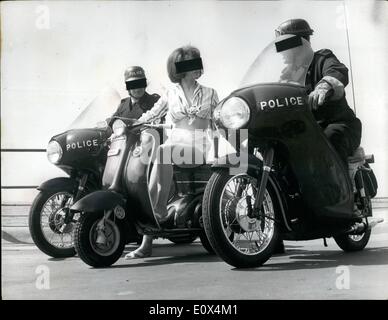 May 05, 1965 - A Fair Cop Photo Shows: Two Blackpool motorcycle policemen, take an interest in Christina Swain, of Nuneaton, when she tried out a new ''Tina'' motor scooter on the promenade at Blackpool, prior to the opening of the International Cycle and Motorcycle Show. Stock Photo