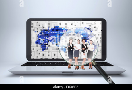 four women standing on a laptop under a magnifying glass Stock Photo