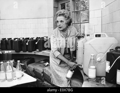 Barbara Cartland filling a glass bottle Stock Photo