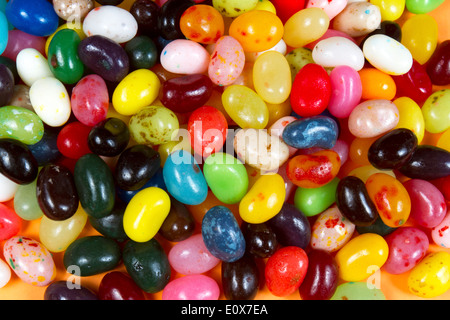 Bright, colorful Easter jellybeans piled on orange paper Stock Photo