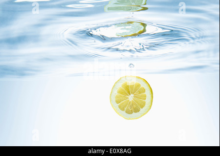 a lemon half falling in water Stock Photo