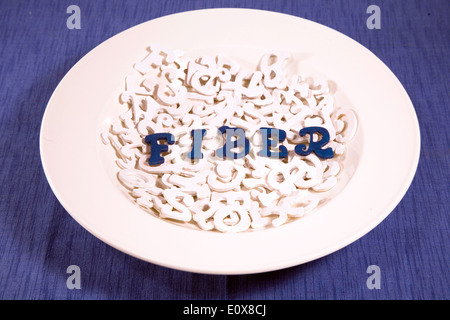 Blue letters in white bowl of white letters spelling Fiber. Stock Photo