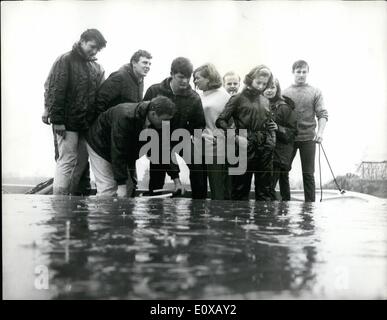 Nov. 11, 1965 - Testing the unsinkable Dory: Eight employees of a boat-building firm of Chichester, Sussex, and two models hired for the day yesterday tested the unsinkable qualities of a six seater Dory, named after the flat-bottomed boats of Newfoundland on Bedfont lake, Middlesex. The ten people on board rocked the boat to fill it with water to prove that it wouldn't sink and it didn't. It did however, capsize, and the people aboard had to swim ashore. Mr Stock Photo