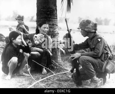 Mar 7, 1966; Viet Cong, Vietnam; South Vietnamese interpreter questions wife of Viet Cong suspect Stock Photo