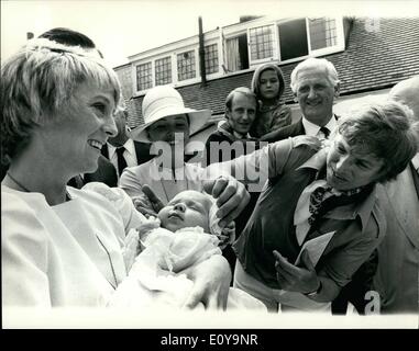 Jun. 06, 1969 - Tommy Steele's Daughter Christened Tommy Steele's daughter, Emma Elizabeth, was christened today at a private ceremony in the garden of their home, Teddington. The ceremony was performed by Father John Bebb, who officiated at Today's wedding. Photo Shows: Tommy wipes his daughter's head with cotton wool after the christening ceremony. Emma Elizabeth is held in the arms of his godmother, Polly James, who appeared with Tommy in ''Half a sixpence'' in New York. Stock Photo