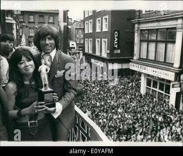Jul. 07, 1969 - Barry Gibb of the Bee  Receives Award for being Best-dressed personality of the year: Barry Gibb of the Bee Gees was today presented with the John Stephan Silver Statuette worth '&pound;500 by Miss Tsai China, star of ''The Virgin Soldiers - for being the best-dressed personality of the year. The Statuette is a figure of Beau Brummel measuring 12''high. The presentation, which took place at Stephen House, Carney by Street, was attended by many pop stars. Photo Shows Above Carney Street packed with fame - Barry Gibb Receives his award from Miss Tsai China today. Stock Photo