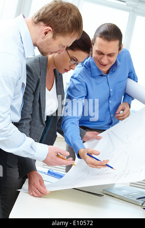 Three engineers examining a sketch of plane Stock Photo